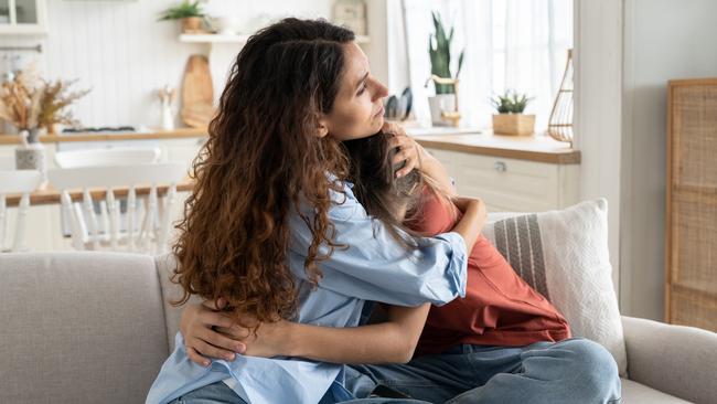 Caring loving mother comforting hugging unhappy sad teenage daughter, sitting together on sofa at home, mom supporting depressed teen girl child, parent making peace with kid. Parenting of adolescentsmum hug teenager daughter   istock image