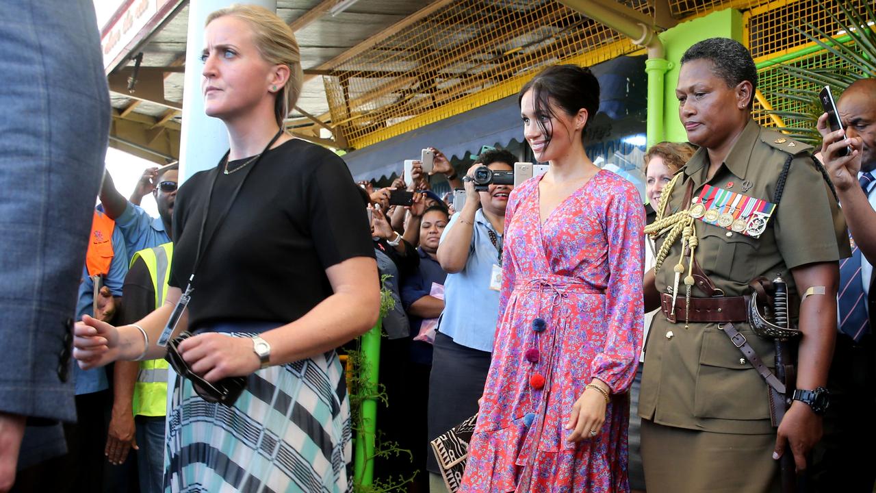 Meghan’s female bodyguard Amy Pickerill (left) helps escort her quickly out of a Fijian marketplace after security concerns during last year’s royal tour. Picture: Nathan Edwards