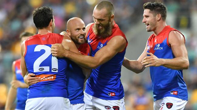 Nathan Jones celebrates a goal with Cam Pedersen, Max Gawn and Jesse Hogan.