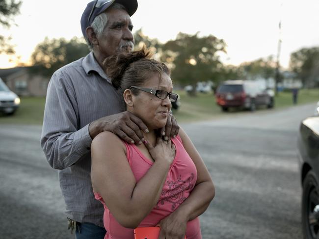 Enrique and Gabby Garcia watch investigators at the scene of a mass shooting at the First Baptist Church in Sutherland Springs, Texas. Picture: AP