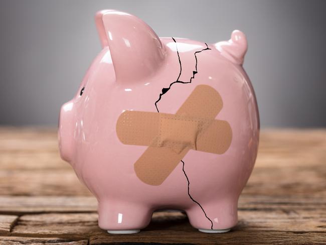 Closeup of broken pink piggybank with bandage on wood, savings generic, cracked and band aid