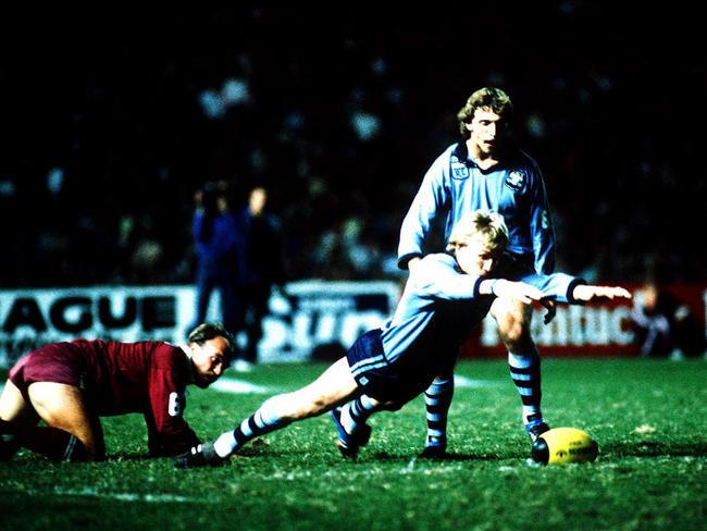 Garry Jack dives to retrieve ball after a tackle by Wally Lewis (L) as Brett Kenny looks on.