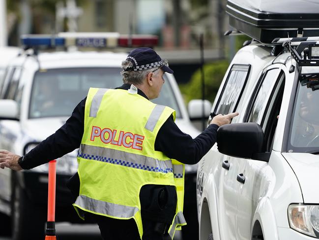 A Queensland police officer speaks with a motorist at a checkpoint at Coolangatta on the Queensland-New South Wales border. Picture; AAP.