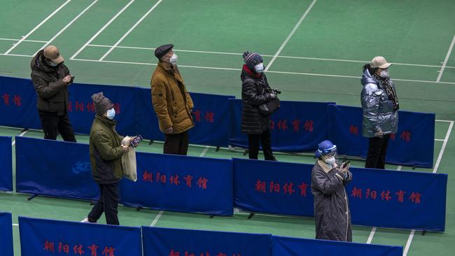 People queue at a clinic set up in a sports centre in Beijing. Picture: Getty Inages