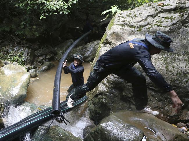 Thai soldiers drag a water pipe to bypass water from entering the cave. Picture: Supplied