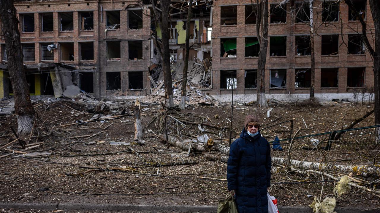 A woman stands in front of a destroyed building after a Russian missile attack in the town of Vasylkiv, near Kyiv, on February 27, 2022. Picture: Dimitar Dilkoff/AFP