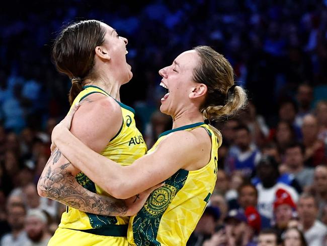 Australia's #15 Cayla George (C-L) and teammates celebrate after Australia won the women's preliminary round group B basketball match between Australia and France during the Paris 2024 Olympic Games at the Pierre-Mauroy stadium in Villeneuve-d'Ascq, northern France, on August 4, 2024. (Photo by Sameer Al-Doumy / AFP)