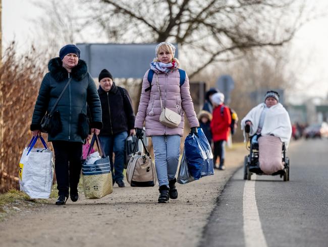 People walk with their belongings at the Astely-Beregsurany border crossing as they flee Ukraine. Picture: Getty