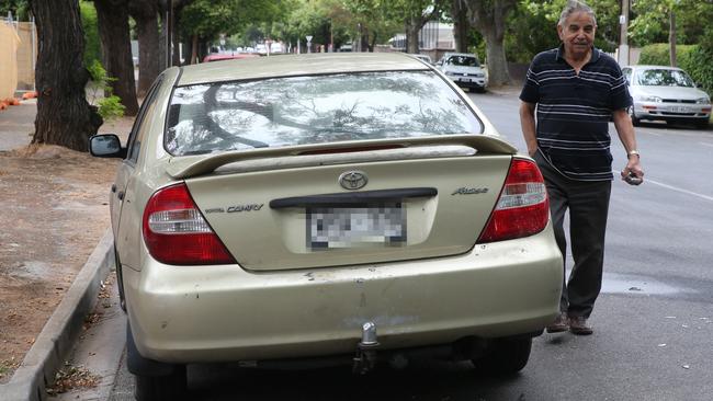 Domenico Demassi, who lives on George St in a house adjacent to where the event took place, looks at one of the cars involved in the crash. Picture: Dean Martin