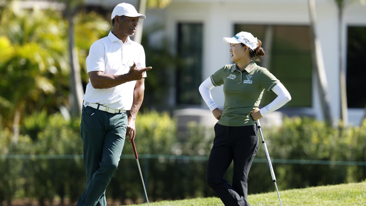 Former NFL player Marcus Allen and Minjee Lee leaning on her new broomstick putter. Picture: Cliff Hawkins/Getty Images