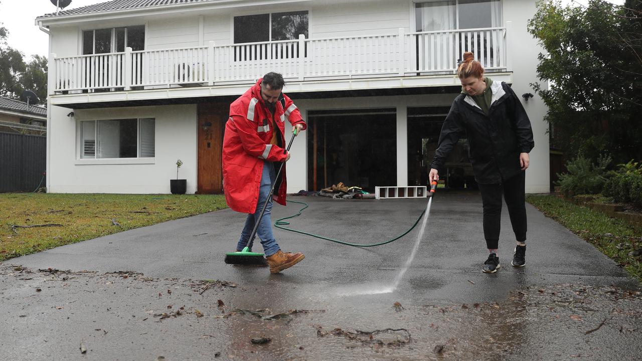 Sarah and Robert Allen had to hose flood water debris off their driveway in Windsor. Picture: John Grainger