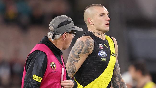 A concussed Martin makes his way to the bench with the club doctor during the third quarter. Picture: Michael Klein