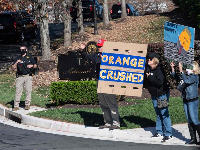 Supporters and protesters of Donald Trump stand outside the Trump International Gold club as the motorcade passes in Sterling, Virginia. Picture: AFP