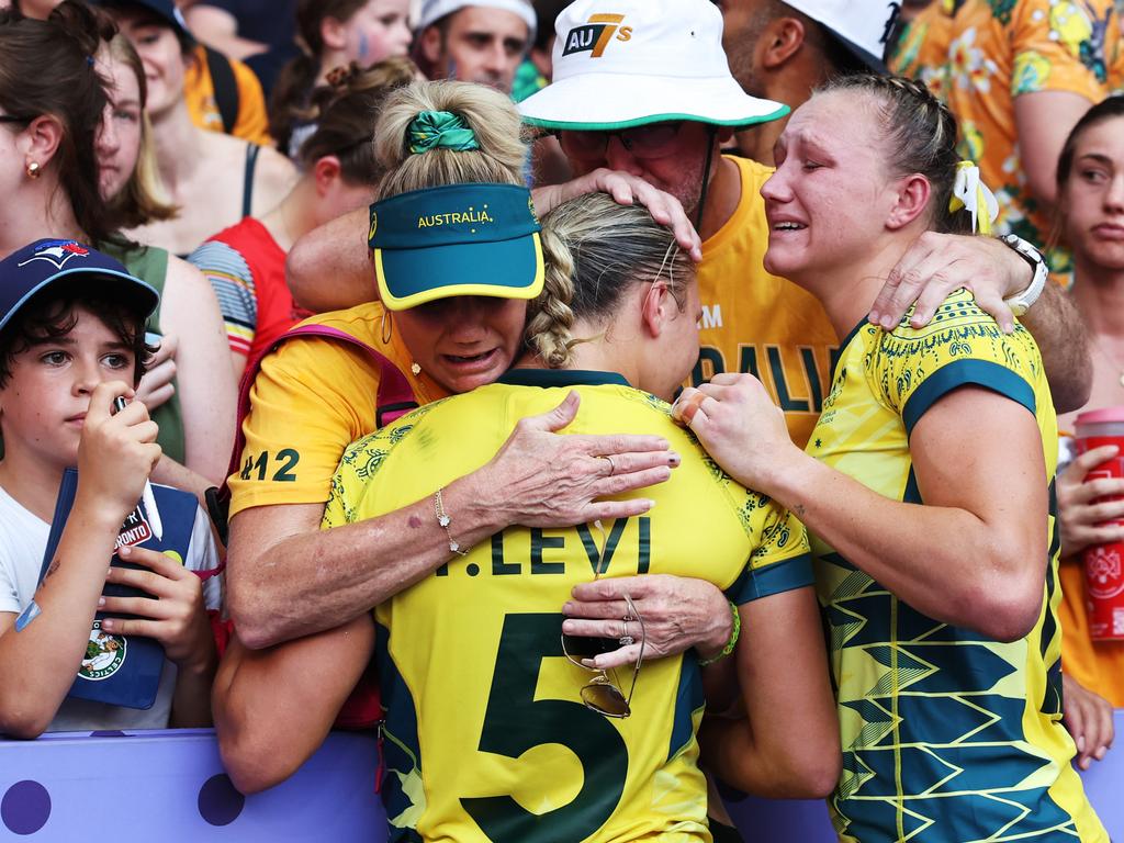 Teagan Levi and Maddison Levi of Team Australia are comforted by members of the crowd following defeat during the Women's Rugby Sevens Bronze medal match. (Picture: Cameron Spencer/Getty Images.