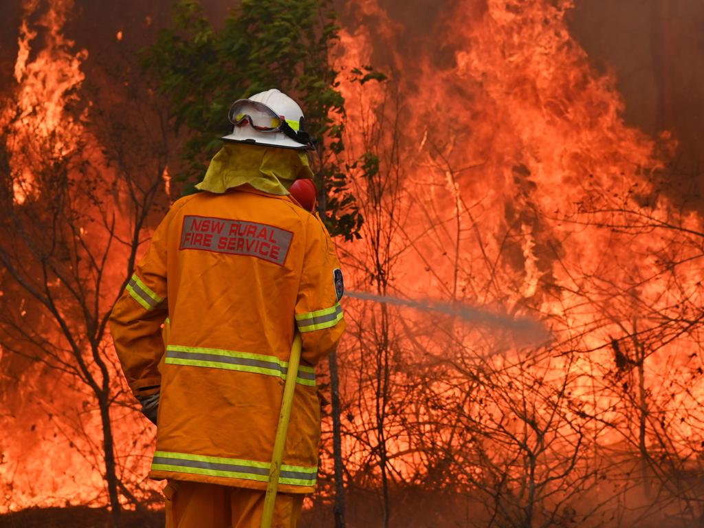 Firefighters tackle a bushfire to save a home in Taree, 350km north of Sydney on November 9, 2019. Picture: Peter Parks/AFP