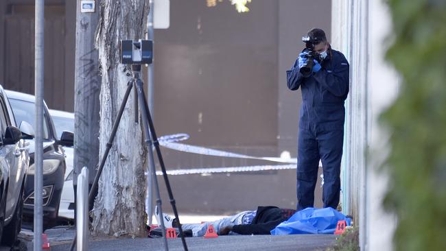 Forensics police examine a body on Langford Street North Melbourne. Picture: Andrew Henshaw