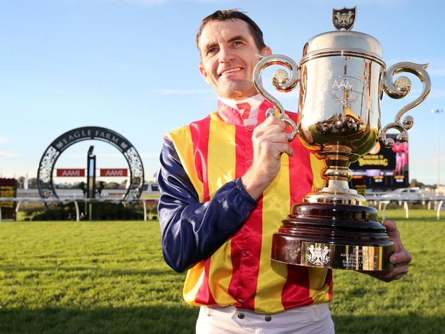 Jockey Dwayne Dunn with the winner’s trophy after Under The Louvre won the Stradbroke Handicap. Picture: Jono Searle