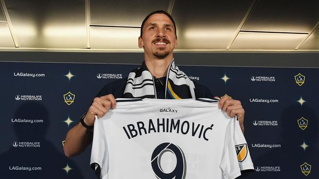 LA Galaxy footballer Zlatan Ibrahimovic holds up a team jersey during his first press conference for the club