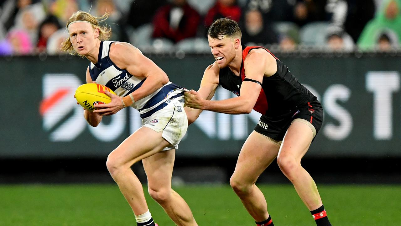 MELBOURNE, AUSTRALIA - JUNE 29: Oliver Dempsey of the Cats is tackled by Jordan Ridley of the Bombers during the round 16 AFL match between Geelong Cats and Essendon Bombers at Melbourne Cricket Ground, on June 29, 2024, in Melbourne, Australia. (Photo by Josh Chadwick/AFL Photos/via Getty Images)