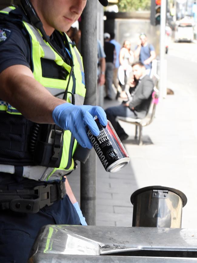 Police throw his alcohol can away. Picture: Nicole Garmston