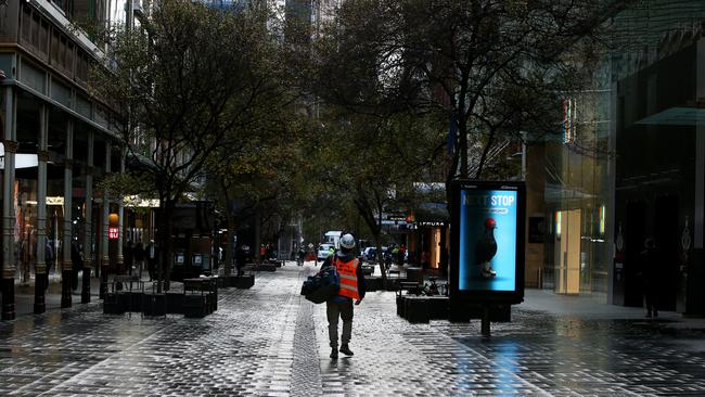 A lone worker makes their way through the usually bustling Pitt Street Mall in Sydney. Picture: Getty Images