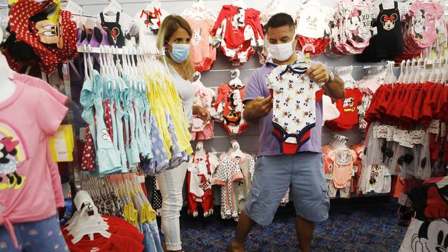 Nikki Hastings and Carlos Aguilera shop for baby merchandise at Disney World in Florida.