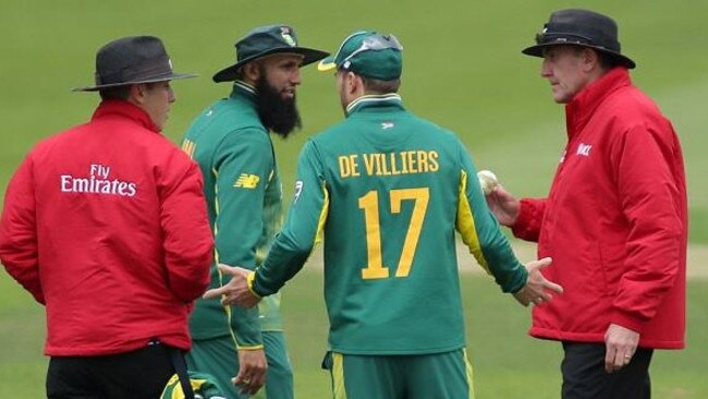 South Africa skipper AB de Villiers hasa word with a the two umpires.