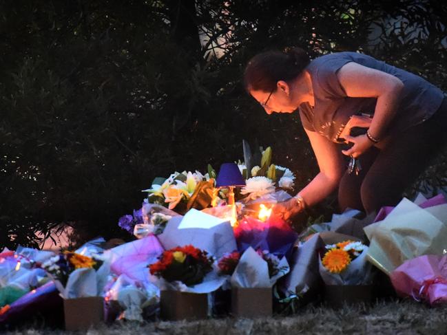 People gather and lay flowers at the site where Aiia Maasarwe was murdered. Picture: Tony Gough