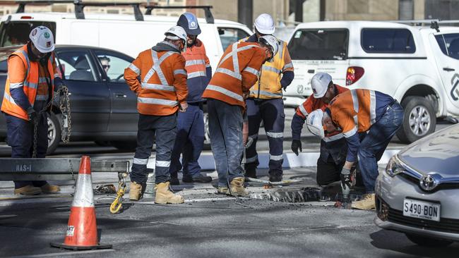 Workers at the tram rail on North Terrace outside Government House. Picture: AAP / Mike Burton