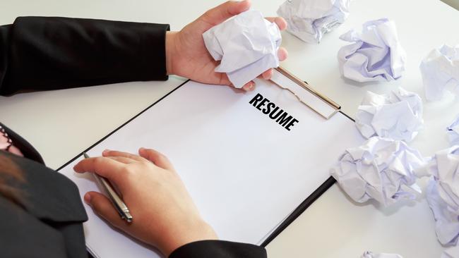 CAREERS: Hands of woman crumple sheets of Resume at the desk, mistake resume.