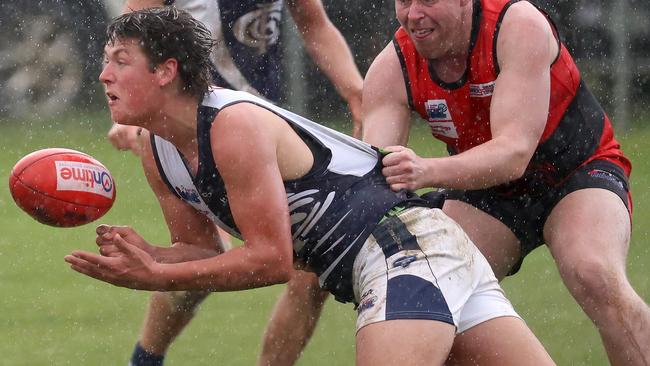 Evan Donoghue dishes out a handball for Melton Centrals. Picture: Hamish Blair