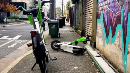 An e-bike and fallen e-scooter obstructing a footpath in the City of Yarra.