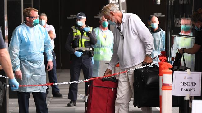 Travellers are escorted to their hotel rooms. Picture: AFP