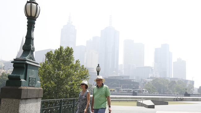 A couple walk through the Melbourne CBD, which has been blanketed by smoke. Picture: David Caird