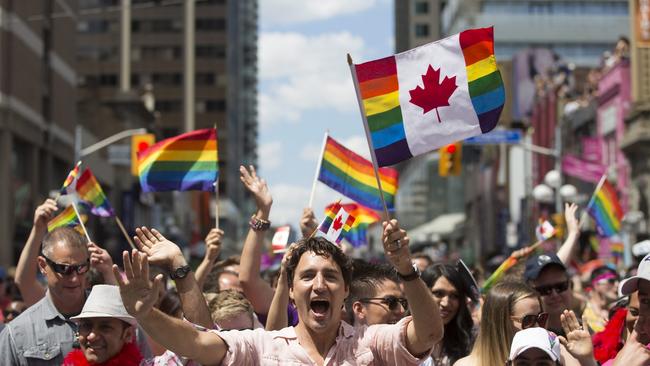 Prime Minister Justin Trudeau waves a flag as he takes part in the annual Pride Parade in Toronto on Sunday, July 3, 2016. (Mark Blinch/The Canadian Press via AP)