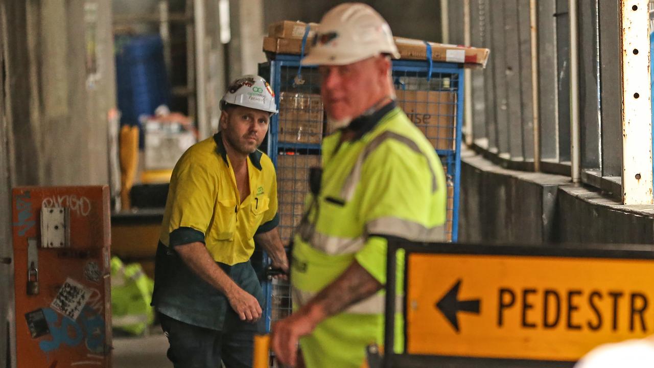 Workers leave the Probuild worksite on 443 Queens Street. Picture: Zak Simmonds