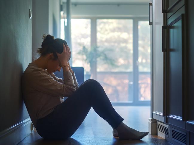 istock generic:  woman, abuse, DV, domestic violence, harassment, sexual harassment.   Sad Young Woman Sitting on the Floor In the Hallway of Her Appartment, Covering Face with Hands. Atmosphere of Depression, Trouble in Relationship, Death in the Family. Dramatic Bad News Moment . Picture: istock