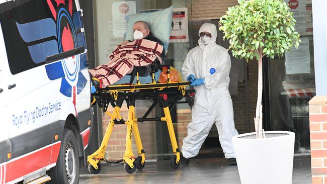 A Covid patient is transferred to a hospital transport at the Arcare Maidstone aged-care centre in Melbourne. Picture: Rob Leeson.