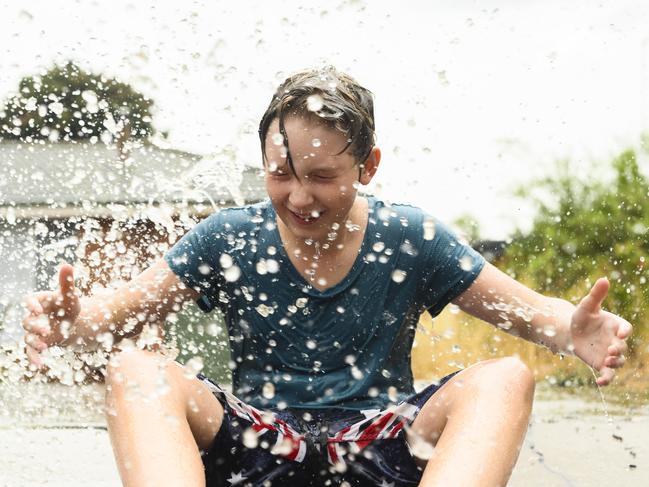 Oscar Lehrmann, 11, playing in the street after heavy rain in Cooma, NSW. Picture: Rohan Thomson