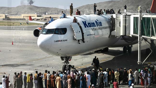 Afghan people climb atop a plane at Kabul’s airport. Picture: AFP