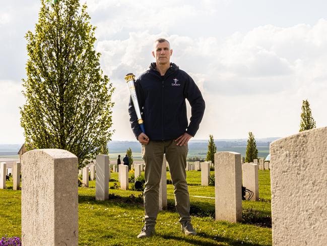 Ken Tsirigotis, of Legacy, by the grave of WW1 digger Henry James Gibb and with Legacy Centenary Relay Torch at the Australian National Memorial outside Villers-Bretonneux, France. Picture: Callum Smith Photography.