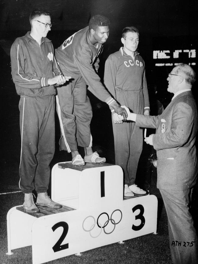 Brundage hands Charles Dumas of the USA his gold medal after his win in the mens high jump at the MCG. In second place Charles Porter of Australia and third, Igor Kashkorov of the USSR.