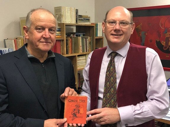 John Black with Dr Neil James from the Plain English Foundation and the World War I copy of Ginger Mick owned by Black's grandfather Bert Tanner. Supplied