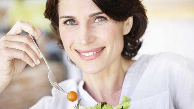 A woman eating a bowl of salad and being happy about it. Maybe she’s a Tasmanian.