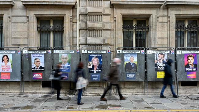 People walk past campaign posters three days ahead of the first round of the French presidential election. Picture: AFP