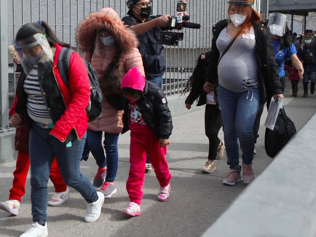 Families of migrants registered under the Migrant Protection Protocols (MPP), cross into the United States accompanied by staff from the United Nations International Organization for Migration (IOM), through the Paso del Norte-Santa Fe international bridge in Ciudad Juarez, Chihuahua state, Mexico on February 26, 2021. (Photo by HERIKA MARTINEZ / AFP)