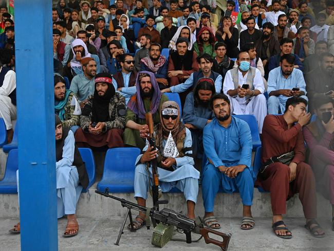 A Taliban fighter (C) keeps vigil as spectators watch a Twenty20 cricket trial match in Kabul. Picture: Aamir Qureshi/AFP