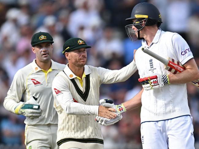 Australia's David Warner (C) shakes the hand of England's Zak Crawley after his monster innings. (Photo by Oli SCARFF / AFP)