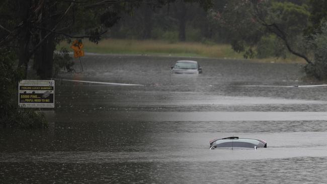 Submerged cars line a normally busy road.