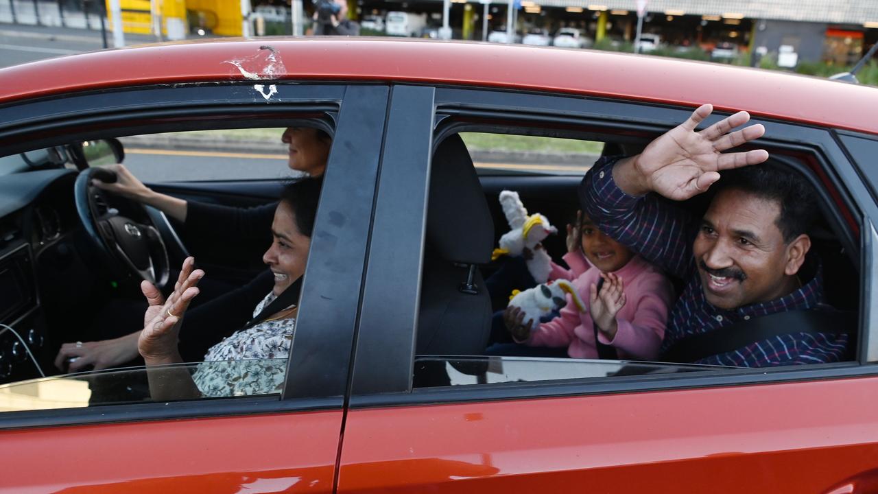 Priya and Nades Murugappan and their daughters Kopika and Tharnicaa wave to media after arriving at Brisbane airport. Picture: NCA NewsWire / Dan Peled.